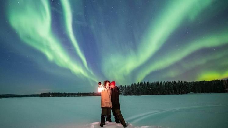 Lorenzo Mirandola con la compagna Luisa sotto un cielo illuminato dall'aurora boreale in Lapponia