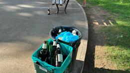 Cestini pieni di bottiglie di alcolici ai giardini di via Calvi