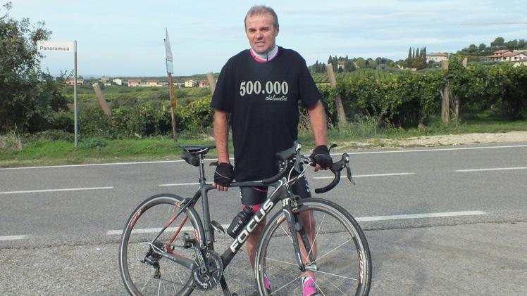 Marco Tosi con la sua bici da corsa e la maglietta dei 500mila chilometri regalatagli dai colleghi