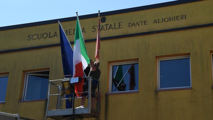 La scuola media Dante Alighieri di Sommacampagna si prepara per la visita di Draghi e cambia le bandiere (foto Pecora)
