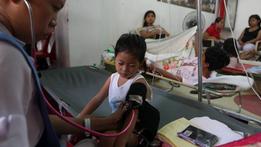 Un infermiere misura la pressione a un bambino affetto da febbre Dengue